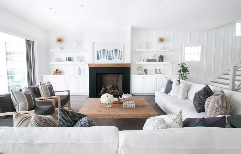 Inspiration for a beach style living room in Orange County with white walls, a standard fireplace and dark hardwood floors.