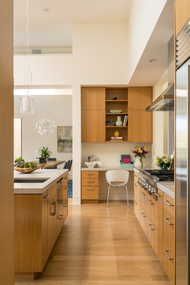 Contemporary eat-in kitchen in San Francisco with an undermount sink, flat-panel cabinets, medium wood cabinets, grey splashback, light hardwood floors, multiple islands and brown floor.