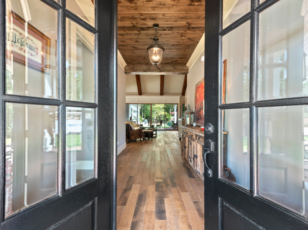 Country front door in Atlanta with grey walls, light hardwood floors, a double front door, a black front door and brown floor.