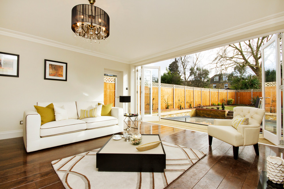 Inspiration for a transitional open concept living room in London with beige walls and medium hardwood floors.