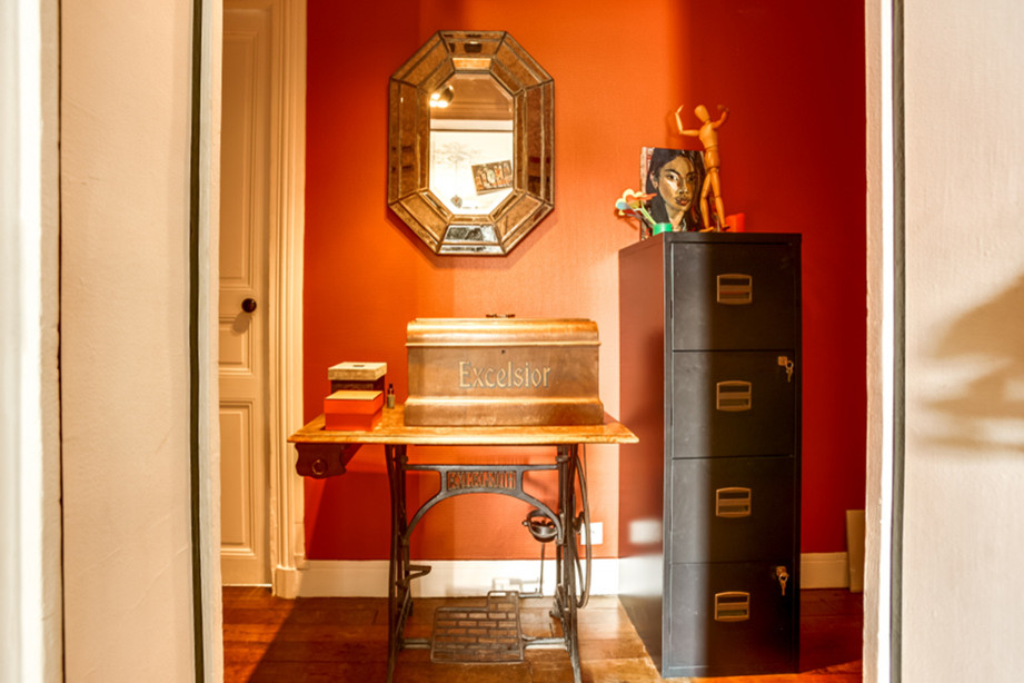 This is an example of a small eclectic hallway in Paris with orange walls, medium hardwood floors and brown floor.