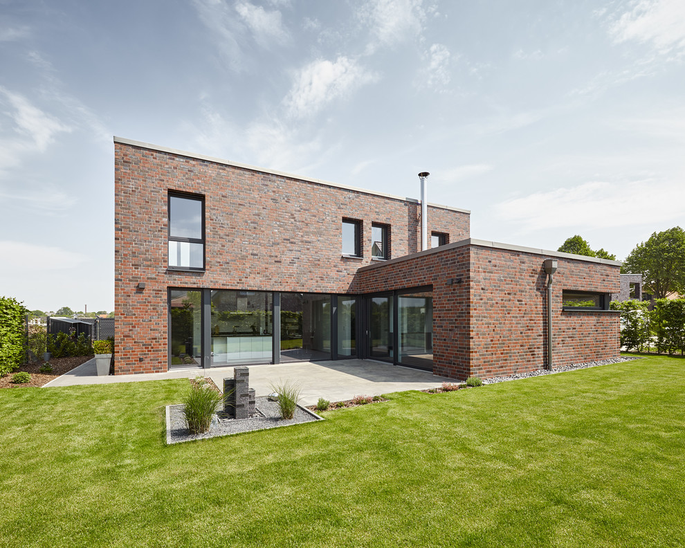 This is an example of a large contemporary two-storey brick exterior in Dusseldorf with a flat roof.