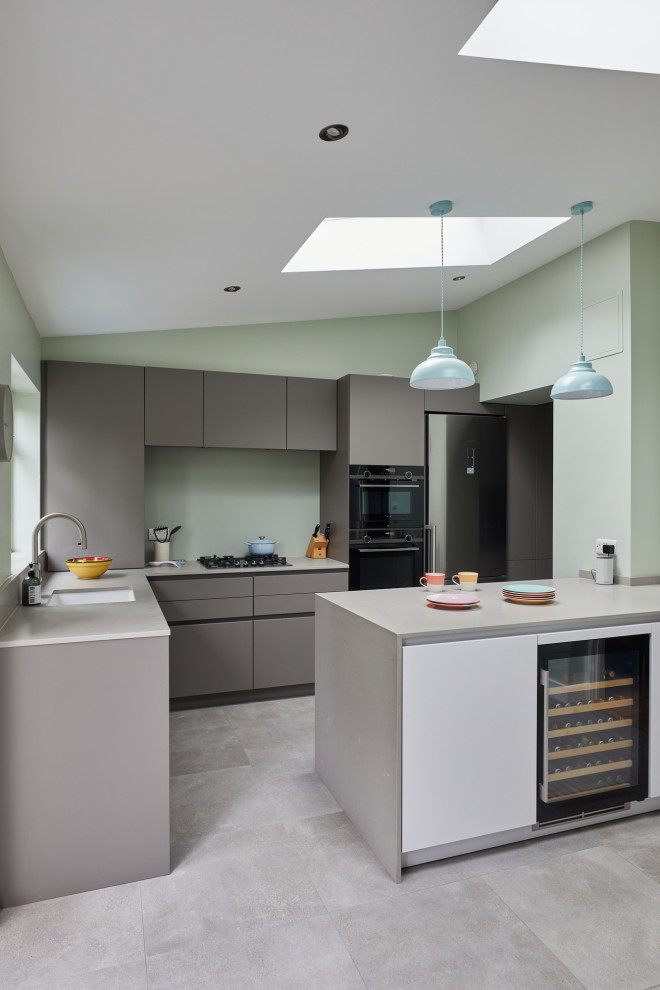 Inspiration for a mid-sized contemporary l-shaped eat-in kitchen in London with an undermount sink, flat-panel cabinets, grey cabinets, quartz benchtops, glass sheet splashback, stainless steel appliances and with island.