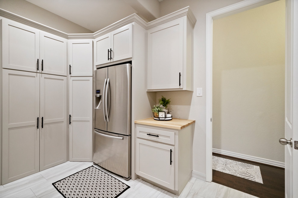 Foto de lavadero actual de tamaño medio con armarios estilo shaker, puertas de armario blancas y encimera de madera