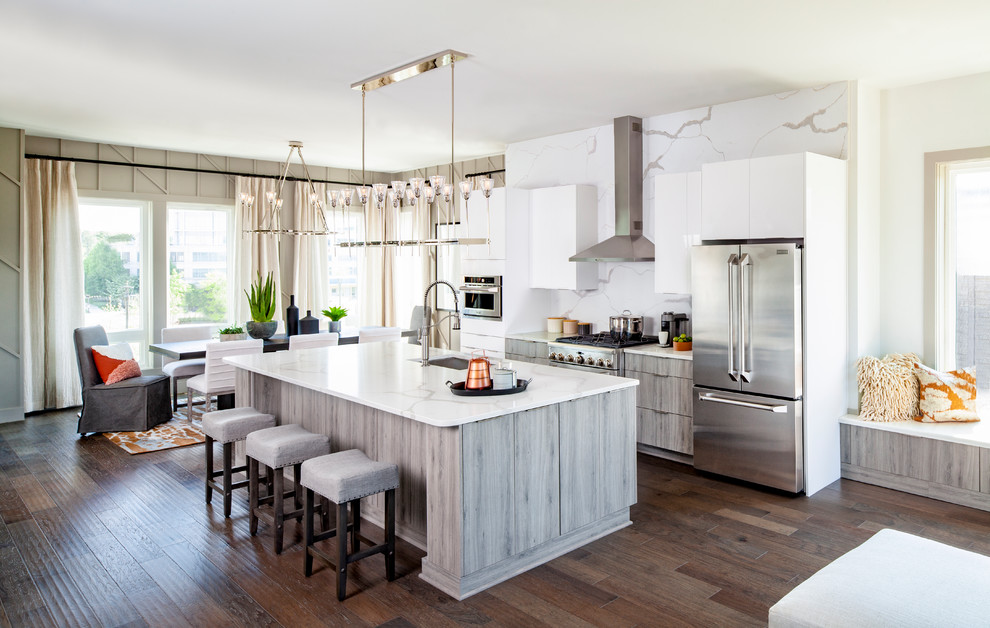 Transitional galley eat-in kitchen in Denver with an undermount sink, flat-panel cabinets, grey cabinets, white splashback, medium hardwood floors, with island, brown floor and white benchtop.