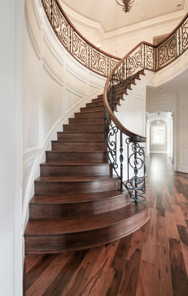Large eclectic wood curved staircase in DC Metro with wood risers and mixed railing.
