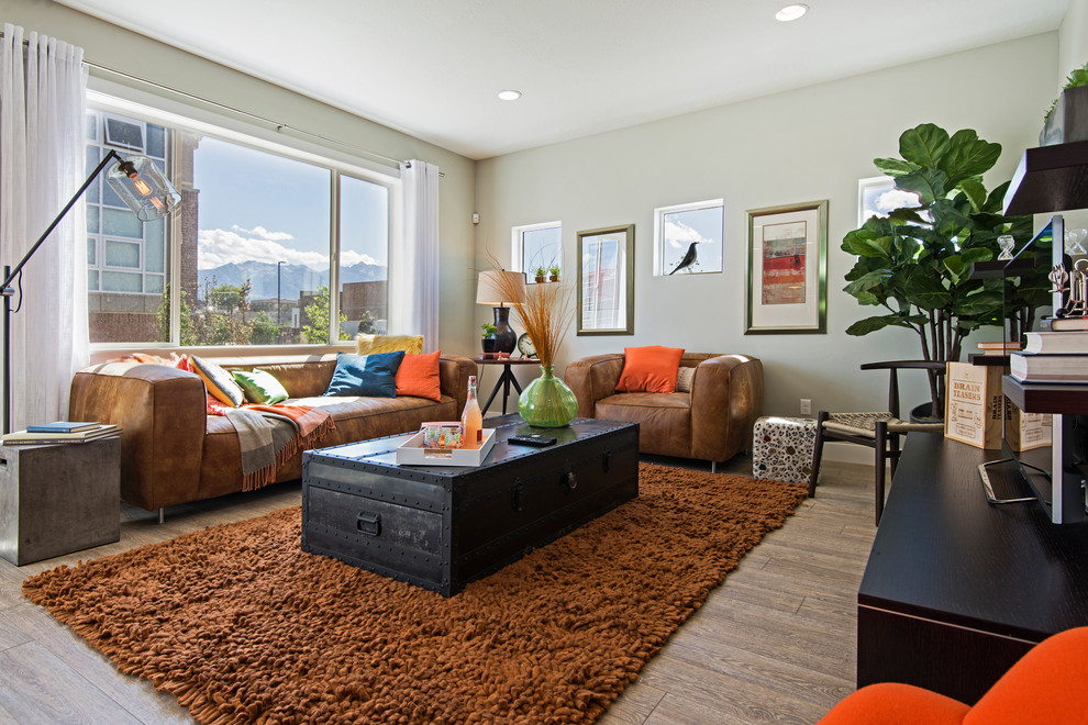 This is an example of a mid-sized transitional open concept family room in Salt Lake City with beige walls, light hardwood floors, no fireplace and a freestanding tv.