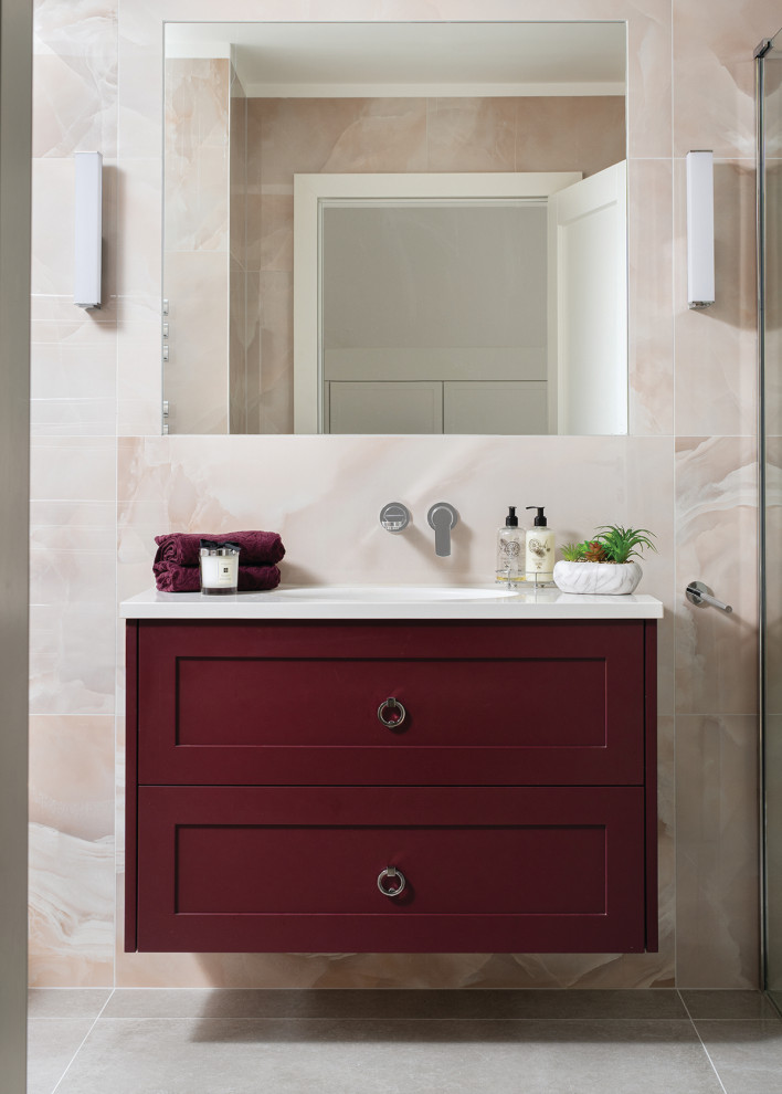 Idées déco pour une grande salle de bain principale moderne avec un placard à porte shaker, des portes de placard rouges, une baignoire indépendante, une douche à l'italienne, WC suspendus, un carrelage rose, des carreaux de porcelaine, un mur rose, un sol en calcaire, un lavabo encastré, un plan de toilette en quartz, un sol gris, aucune cabine, un plan de toilette blanc, meuble simple vasque et meuble-lavabo suspendu.