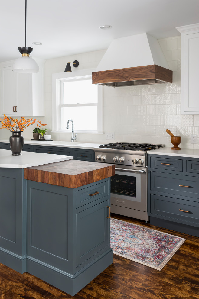 Eat-in kitchen - large transitional l-shaped dark wood floor and brown floor eat-in kitchen idea in Minneapolis with an undermount sink, flat-panel cabinets, blue cabinets, quartz countertops, white backsplash, ceramic backsplash, paneled appliances, an island and white countertops