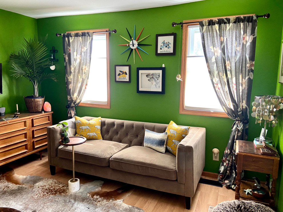 Photo of a small eclectic living room in Cedar Rapids with green walls and a wall-mounted tv.