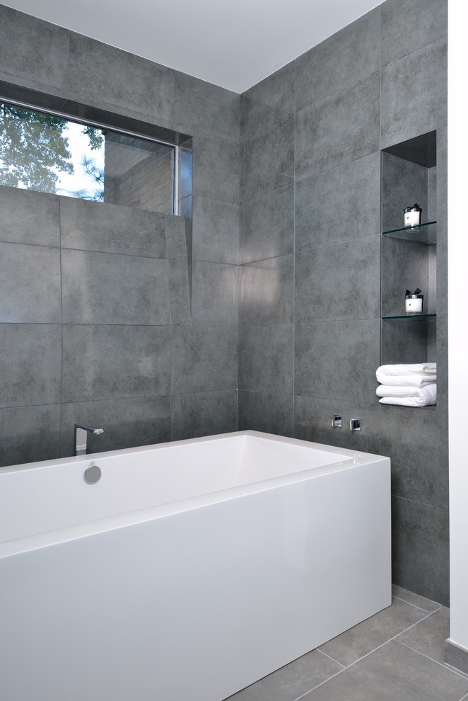 Design ideas for a modern bathroom in Houston with a freestanding tub, gray tile and a niche.