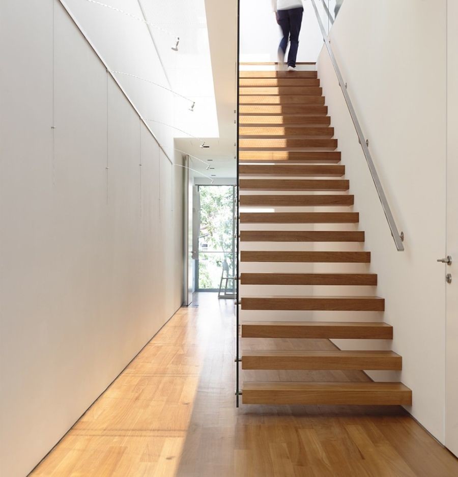 Photo of a mid-sized modern wood floating staircase in Other with open risers and glass railing.