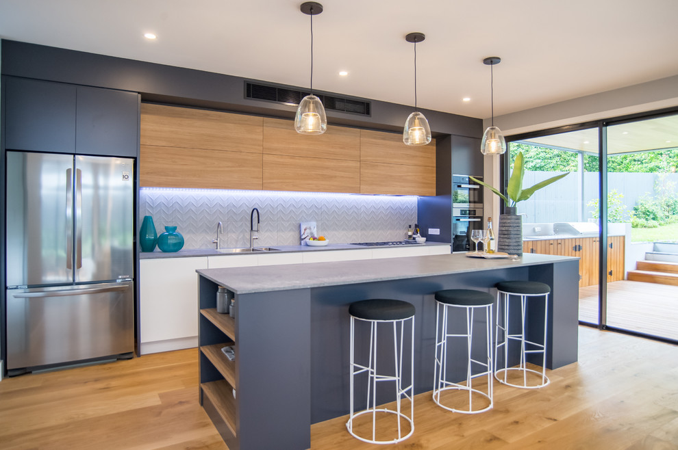 Inspiration for a mid-sized contemporary galley kitchen in Sydney with quartz benchtops, grey splashback, stainless steel appliances, with island, brown floor, grey benchtop, a double-bowl sink, flat-panel cabinets, medium wood cabinets and medium hardwood floors.
