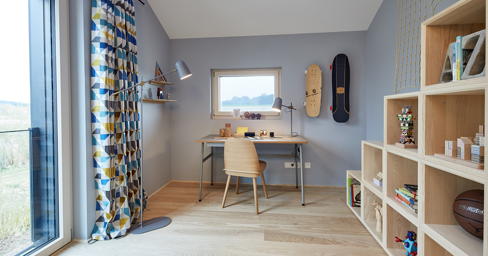 This is an example of a mid-sized contemporary kids' room for boys in Other with blue walls, light hardwood floors and beige floor.