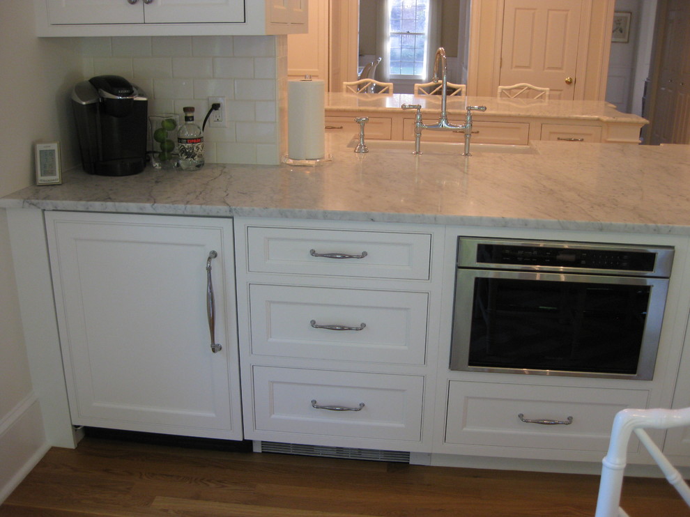 Eat-in kitchen - transitional u-shaped medium tone wood floor eat-in kitchen idea in Boston with a farmhouse sink, beaded inset cabinets, white cabinets, marble countertops, white backsplash, subway tile backsplash, stainless steel appliances and an island
