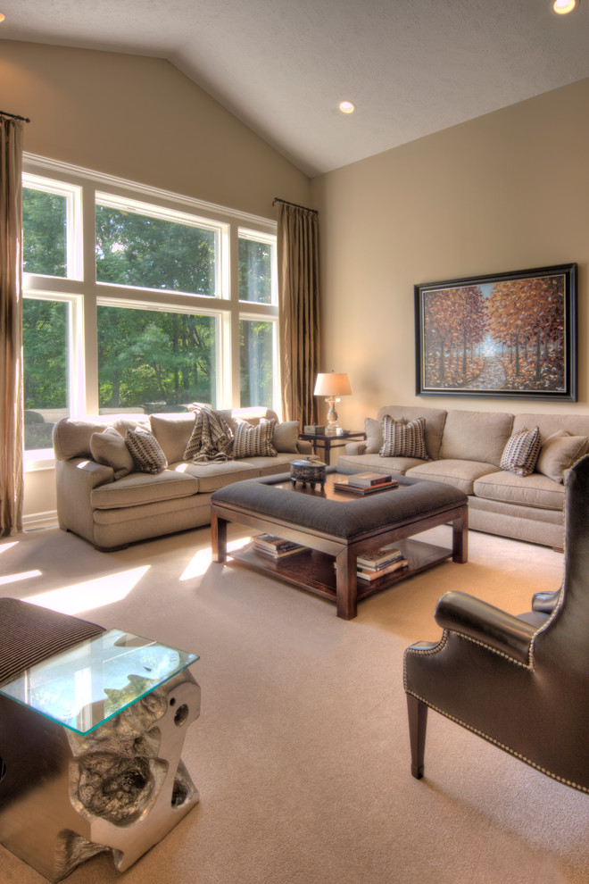 This is an example of a large transitional open concept living room in Other with beige walls, carpet, a standard fireplace, a tile fireplace surround, a wall-mounted tv and beige floor.