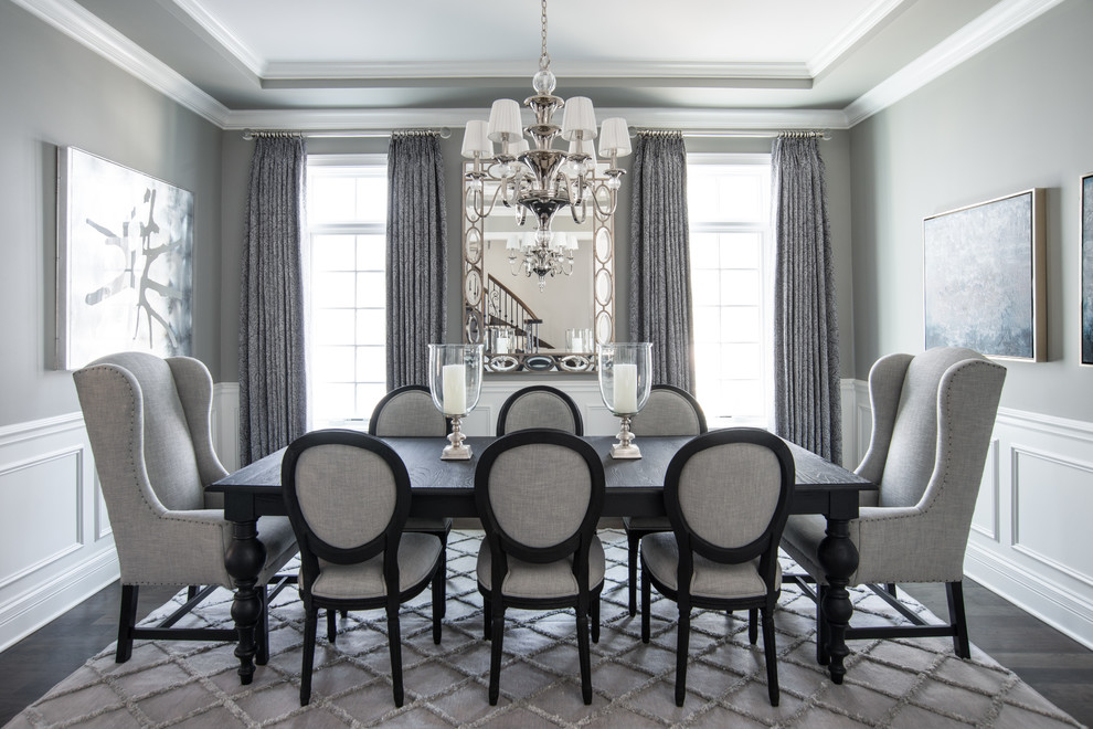 This is an example of a traditional dining room in Chicago with grey walls, dark hardwood floors and no fireplace.