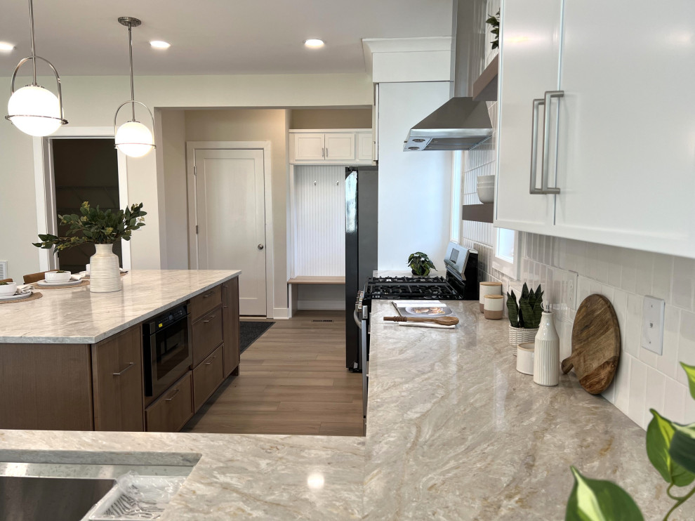Inspiration for a mid-sized transitional l-shaped beige floor kitchen remodel in DC Metro with an undermount sink, shaker cabinets, white cabinets, quartz countertops, white backsplash, ceramic backsplash, stainless steel appliances, an island and beige countertops