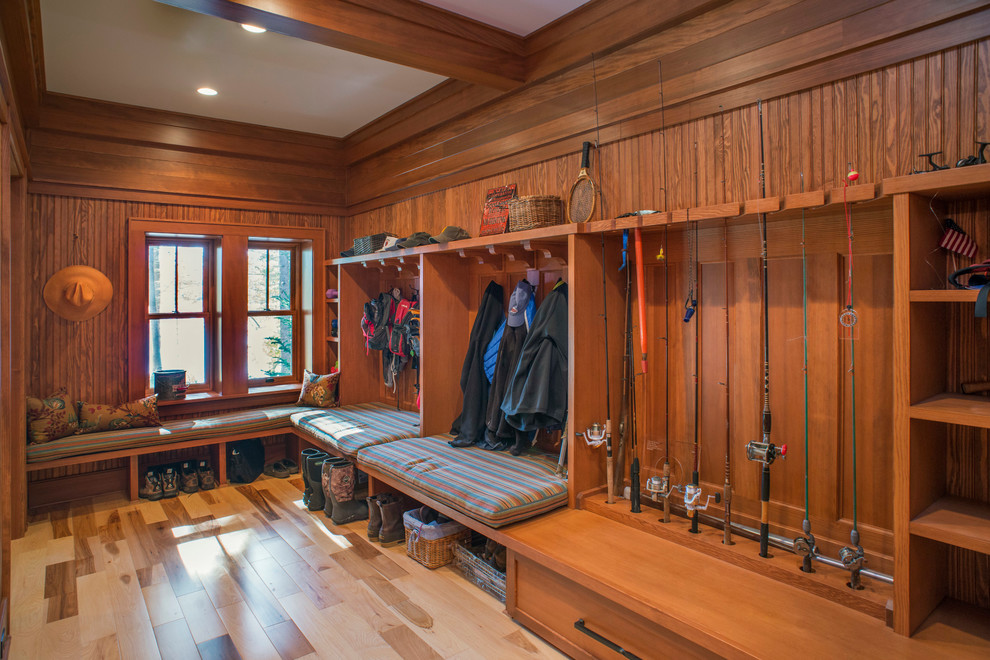 Inspiration for a large country mudroom in New York with brown walls, light hardwood floors and brown floor.