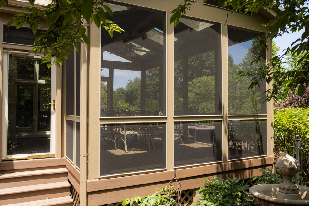 Inspiration for a traditional backyard screened-in verandah in Kansas City with decking, a roof extension and metal railing.