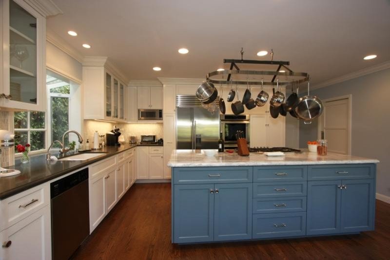 Example of a large transitional l-shaped medium tone wood floor and brown floor eat-in kitchen design in Los Angeles with an undermount sink, shaker cabinets, white cabinets, marble countertops, white backsplash, glass tile backsplash, stainless steel appliances and an island
