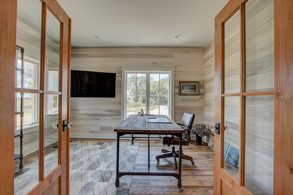 Photo of a large country home office in Milwaukee with a freestanding desk, brown floor and planked wall panelling.