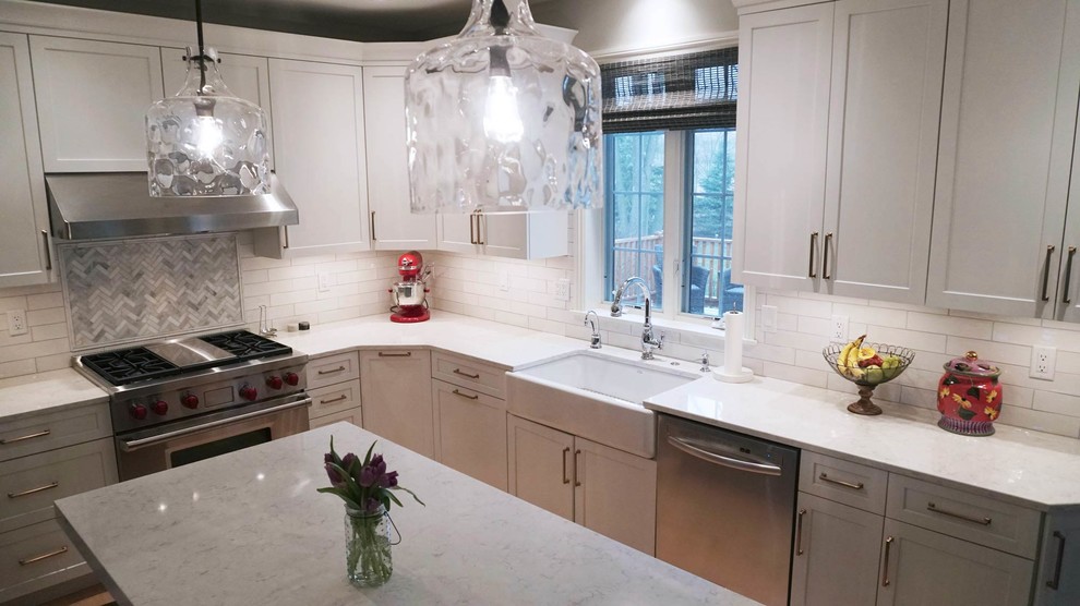 Transitional light wood floor open concept kitchen photo with a farmhouse sink, recessed-panel cabinets, white cabinets, white backsplash, subway tile backsplash, stainless steel appliances, an island and white countertops