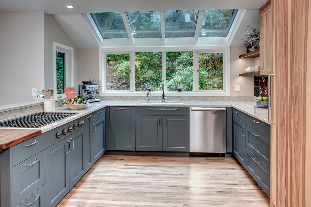 Idéer för att renovera ett stort eklektiskt grå grått kök, med en enkel diskho, släta luckor, blå skåp, bänkskiva i kvarts, flerfärgad stänkskydd, stänkskydd i keramik, rostfria vitvaror, ljust trägolv, en halv köksö och brunt golv