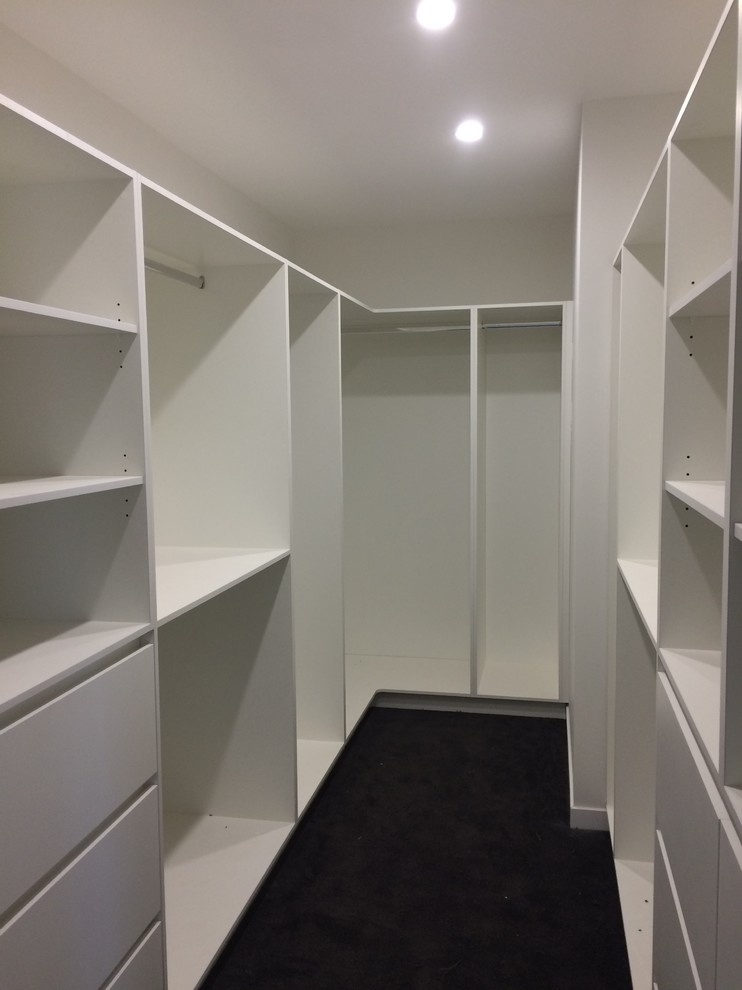 Design ideas for a large contemporary walk-in wardrobe in Brisbane with white cabinets, carpet and grey floor.