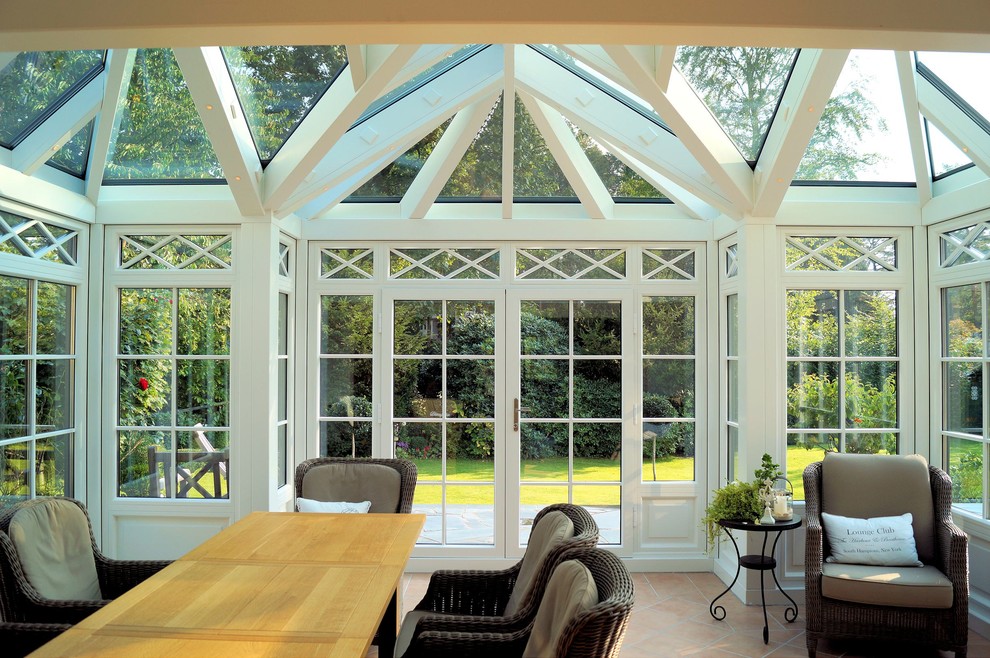 Großer Klassischer Wintergarten mit dunklem Holzboden, Kaminofen, Oberlicht und braunem Boden in Hamburg