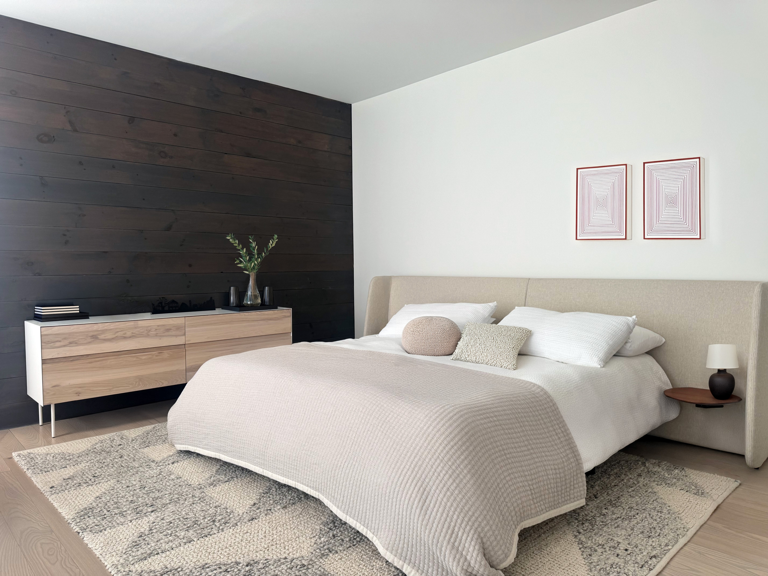 Experience the essence of serene luxury with this contemporary bedroom design. Featuring a rich, dark wood accent wall that adds warmth and depth, balanced by a soft, neutral palette, this space perfe
