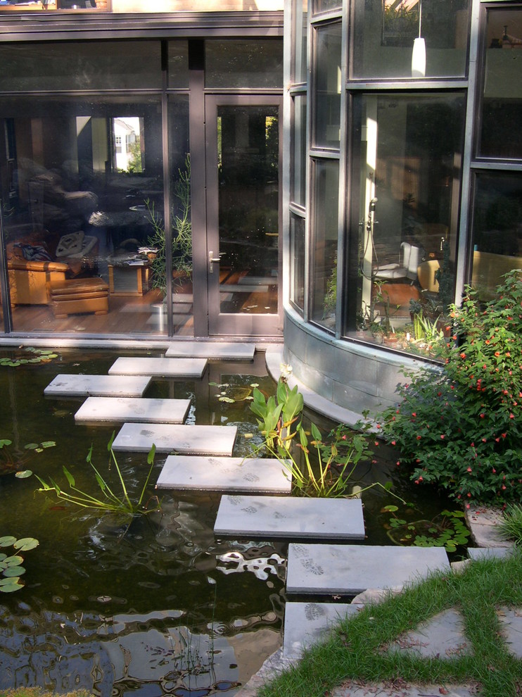 Photo of a mid-sized country backyard partial sun garden in DC Metro with with pond and concrete pavers.