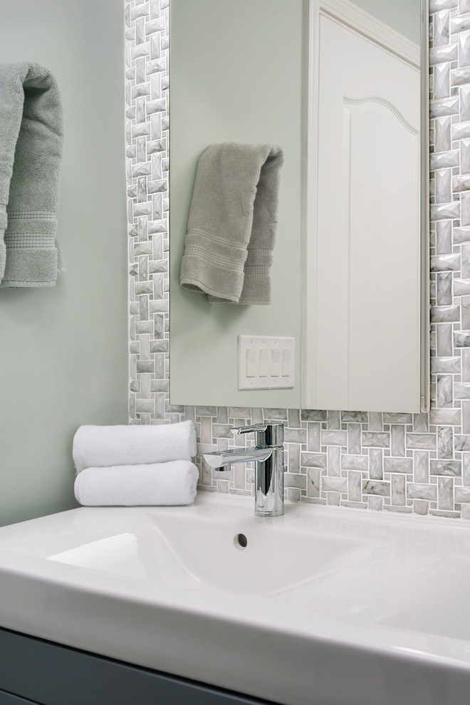 This is an example of a mid-sized contemporary master bathroom in San Francisco with flat-panel cabinets, grey cabinets, an alcove shower, a one-piece toilet, gray tile, grey walls, ceramic floors, an integrated sink, solid surface benchtops, mosaic tile, grey floor and a sliding shower screen.