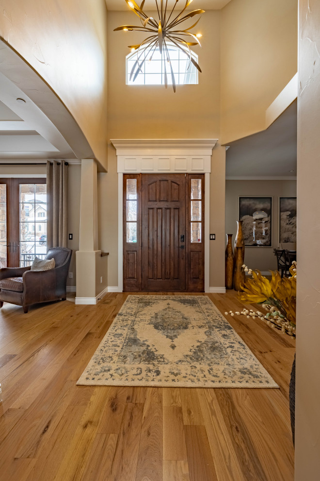 Foto de puerta principal retro de tamaño medio con paredes beige, suelo de madera clara, puerta simple y puerta de madera oscura