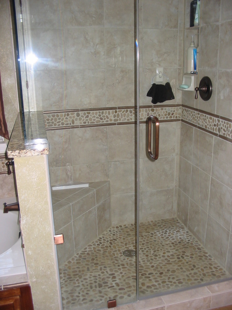 Photo of a mid-sized transitional master bathroom in Milwaukee with an integrated sink, raised-panel cabinets, granite benchtops, a drop-in tub, a corner shower, beige tile, pebble tile, green walls and ceramic floors.
