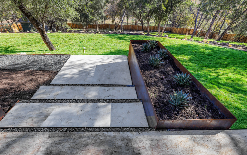 Design ideas for an expansive contemporary front yard partial sun driveway in Austin with with path and concrete pavers.