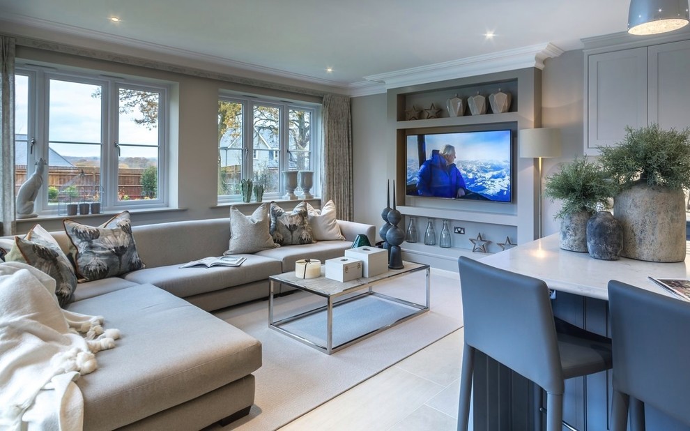Photo of a small transitional open concept living room in Surrey with grey walls, a wall-mounted tv and beige floor.