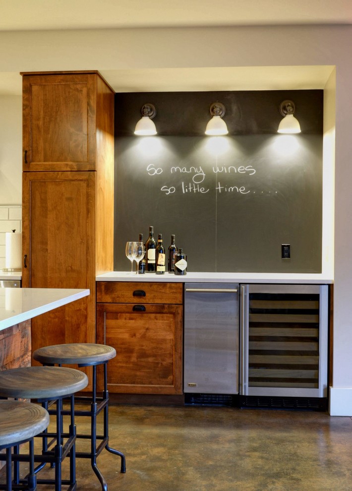 Design ideas for a small traditional single-wall home bar in Seattle with recessed-panel cabinets, dark wood cabinets, quartz benchtops, black splashback and concrete floors.