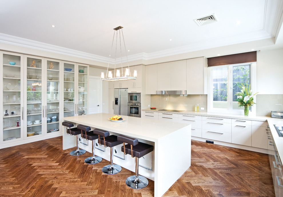 This is an example of a contemporary kitchen in Melbourne with glass-front cabinets and stainless steel appliances.
