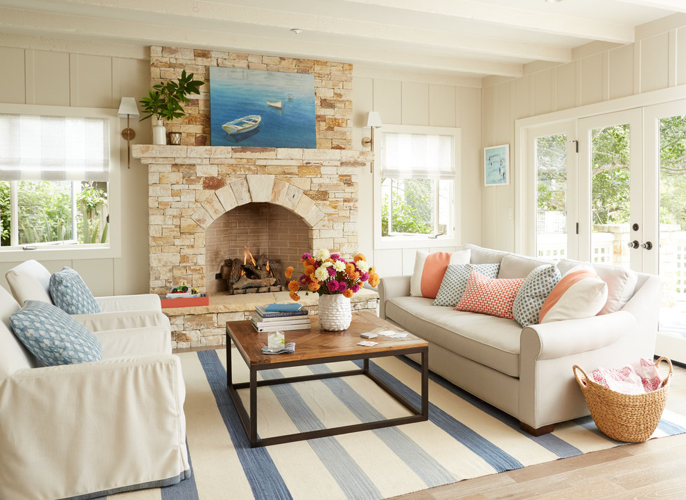 Mid-sized beach style formal enclosed living room in San Francisco with beige walls, a standard fireplace, no tv, light hardwood floors, a stone fireplace surround and brown floor.