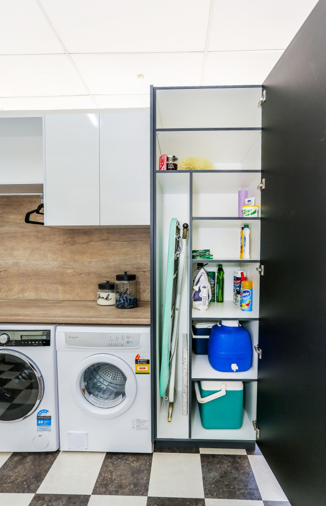 Small contemporary single-wall dedicated laundry room in Other with a drop-in sink, flat-panel cabinets, grey cabinets, laminate benchtops, brown walls, vinyl floors, a side-by-side washer and dryer and brown benchtop.