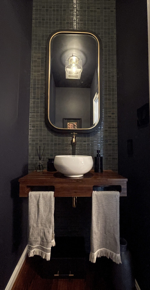 Exempel på ett eklektiskt brun brunt toalett, med skåp i mellenmörkt trä, blå kakel, porslinskakel, blå väggar, mörkt trägolv, ett fristående handfat, träbänkskiva och brunt golv