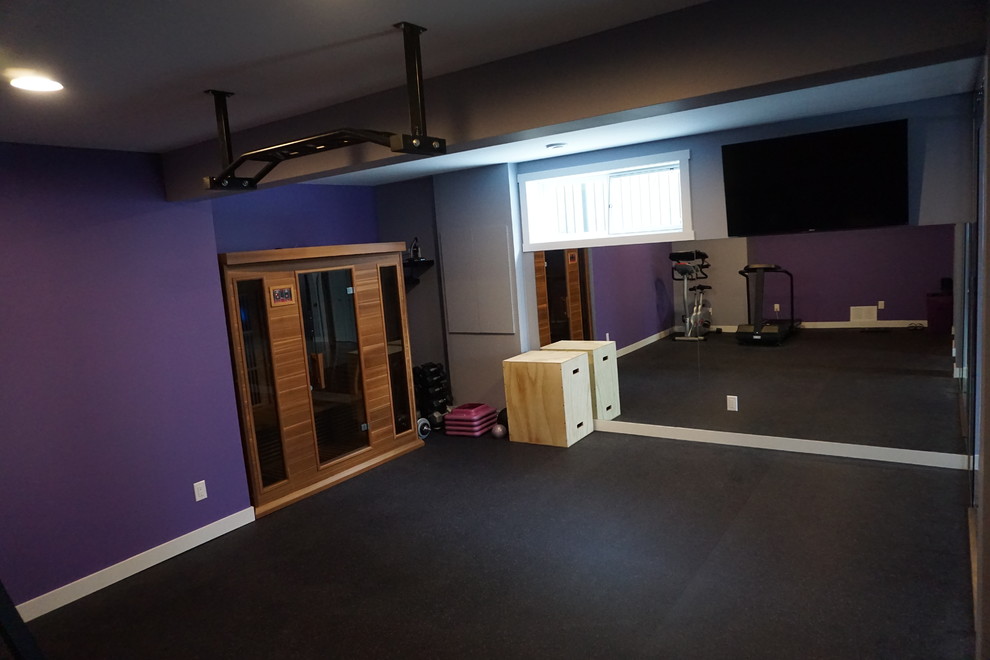This is an example of a large modern home weight room in Calgary with purple walls.