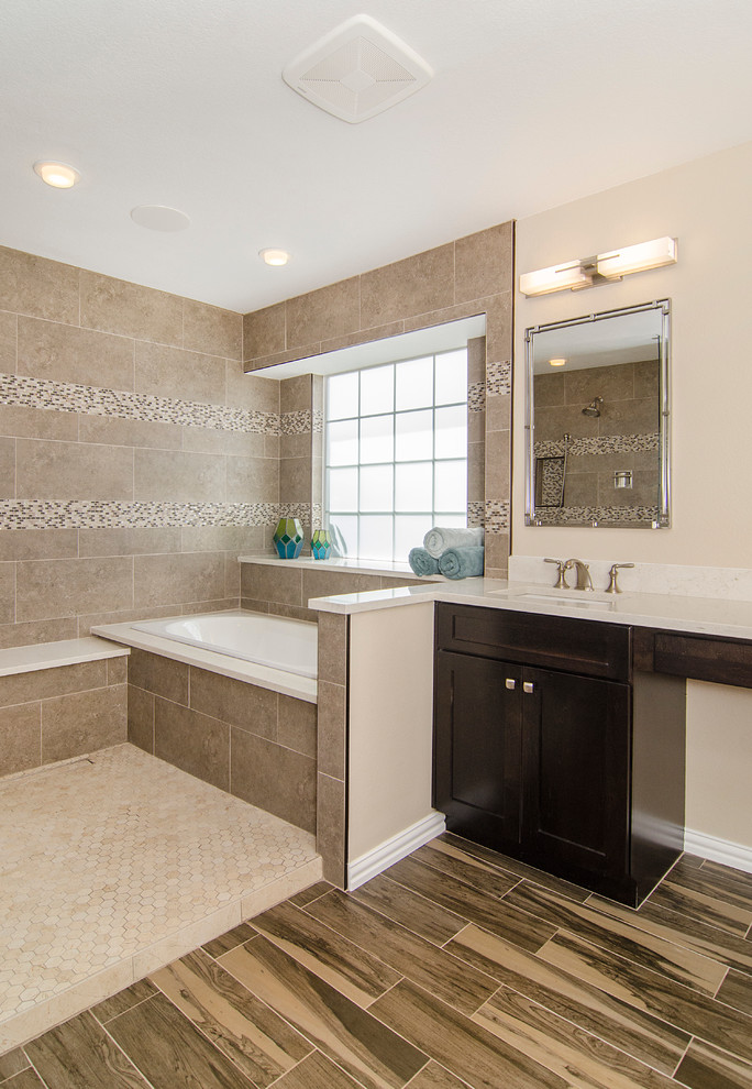 Inspiration for a mid-sized transitional master bathroom in Dallas with an undermount sink, shaker cabinets, dark wood cabinets, solid surface benchtops, an alcove tub, an open shower, a one-piece toilet, brown tile, ceramic tile, beige walls and ceramic floors.