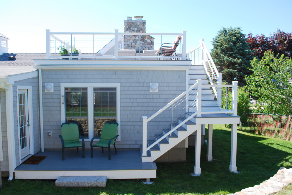 Photo of a mid-sized beach style one-storey grey house exterior in Providence with wood siding, a gable roof, a mixed roof and shingle siding.