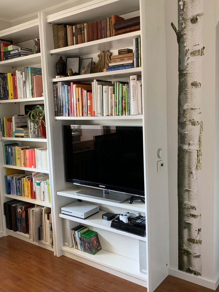 Inredning av ett lantligt litet separat vardagsrum, med ett bibliotek, grå väggar, laminatgolv och en fristående TV