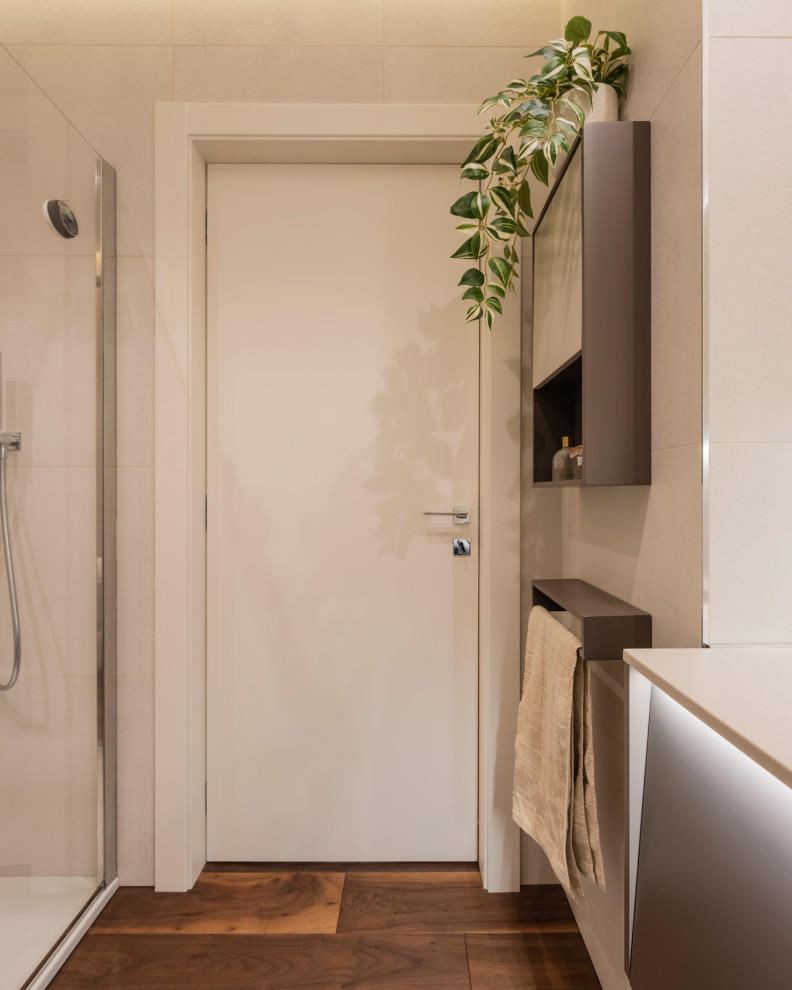 Inredning av ett modernt mellanstort vit vitt badrum med dusch, med släta luckor, beige skåp, en hörndusch, en toalettstol med separat cisternkåpa, rosa kakel, porslinskakel, vita väggar, mörkt trägolv, ett nedsänkt handfat, bänkskiva i kvarts, brunt golv och dusch med skjutdörr