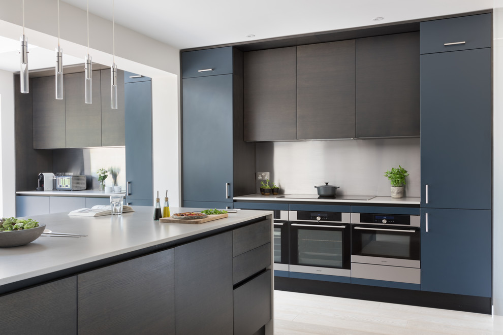 Photo of a large contemporary eat-in kitchen in Sussex with a drop-in sink, flat-panel cabinets, dark wood cabinets, solid surface benchtops, metallic splashback, stainless steel appliances, medium hardwood floors, with island, grey floor and grey benchtop.