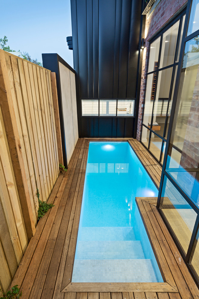 This is an example of a small contemporary side yard rectangular pool in Melbourne with decking.