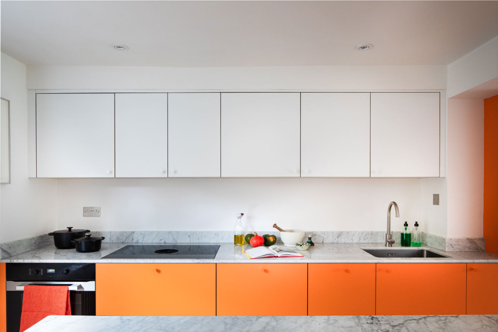 Diseño de cocinas en U contemporáneo grande cerrado con fregadero integrado, armarios con paneles lisos, puertas de armario naranjas, electrodomésticos de acero inoxidable y una isla